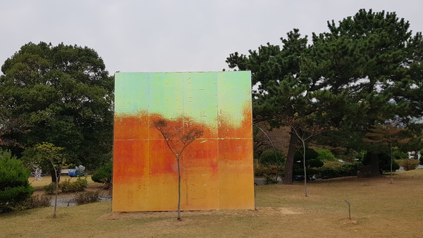 야외공원의 나무 뒤에 캔버스처럼 철판을 설치한 이명호의 '나무 그리고 색창원 #1"