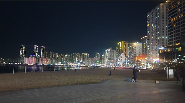 광안리 오른쪽 해변의 야경울 배경으로 버스킹하는 무명 가수@사진 동이